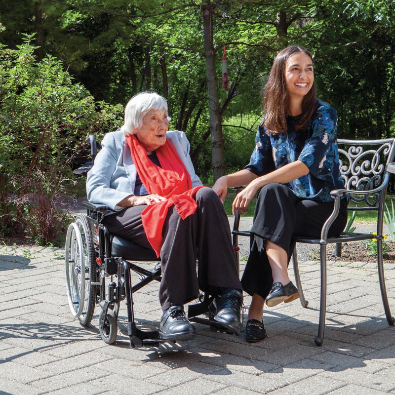 Jean Tucker-Galipeau, in her wheelchair, and her granddaughter Michelle Bloomberg siting on a garden patio.