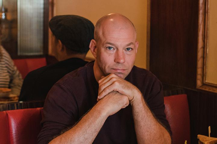 Greg McArthur sits in a diner booth.
