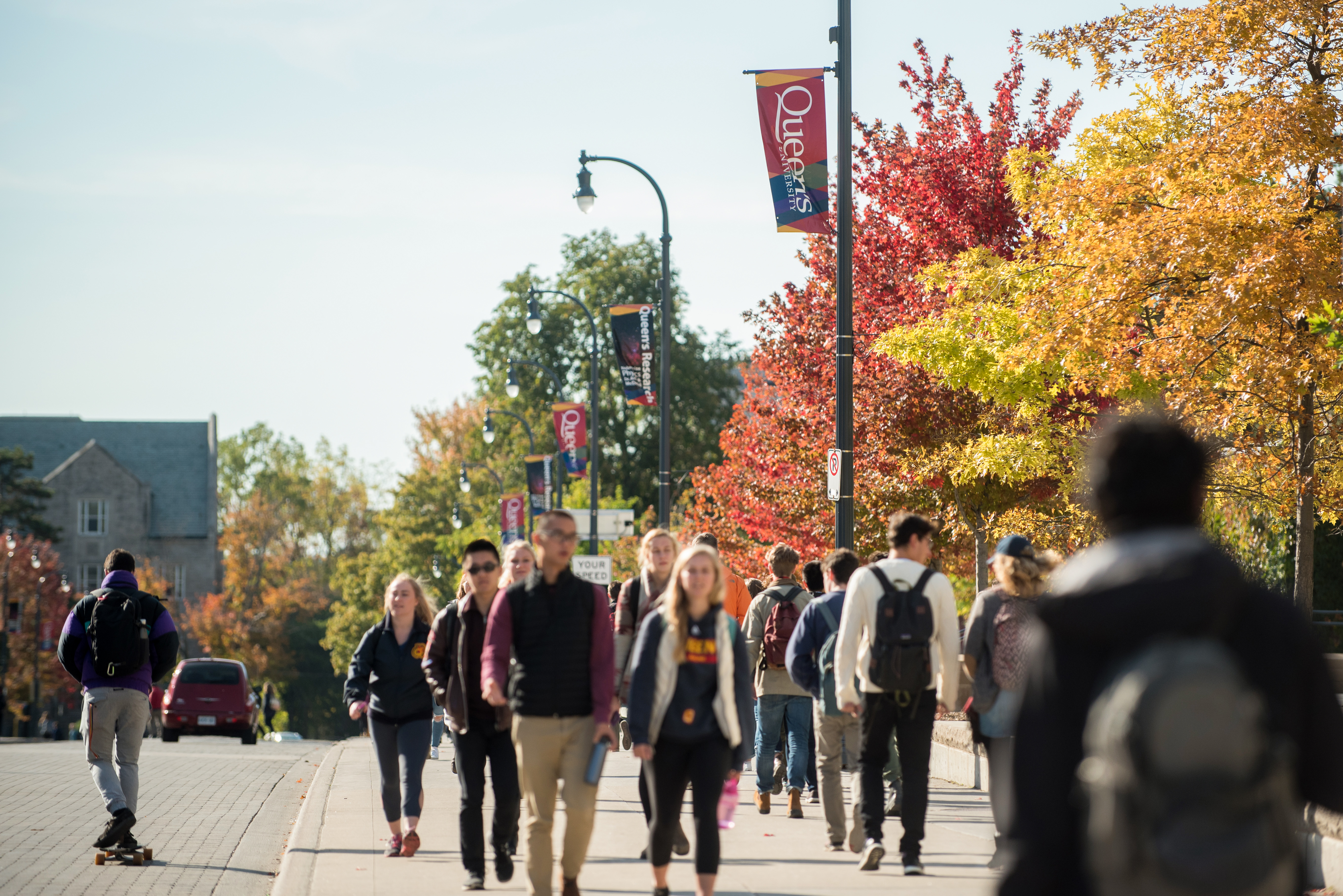 Students walking down the street at Queen's University in the Fall.