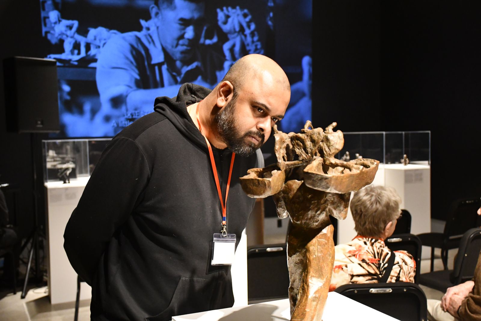 Rito Barua examining a bronze sculpture created by Lui Shimming. 