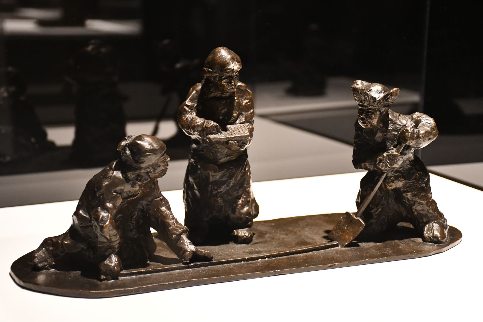 A bronze sculpture depicting farmers working the land. 