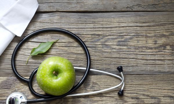 Apple and stethescope to represent human nutrition