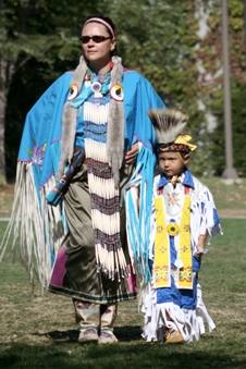 An Indigenous woman and child dressed in ceremonial clothing a Powwow hosted at Queen's University. 