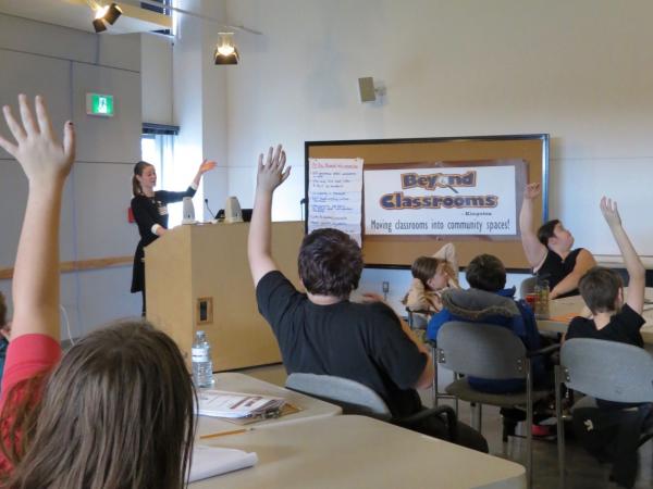 Kids raising hands in a classroom