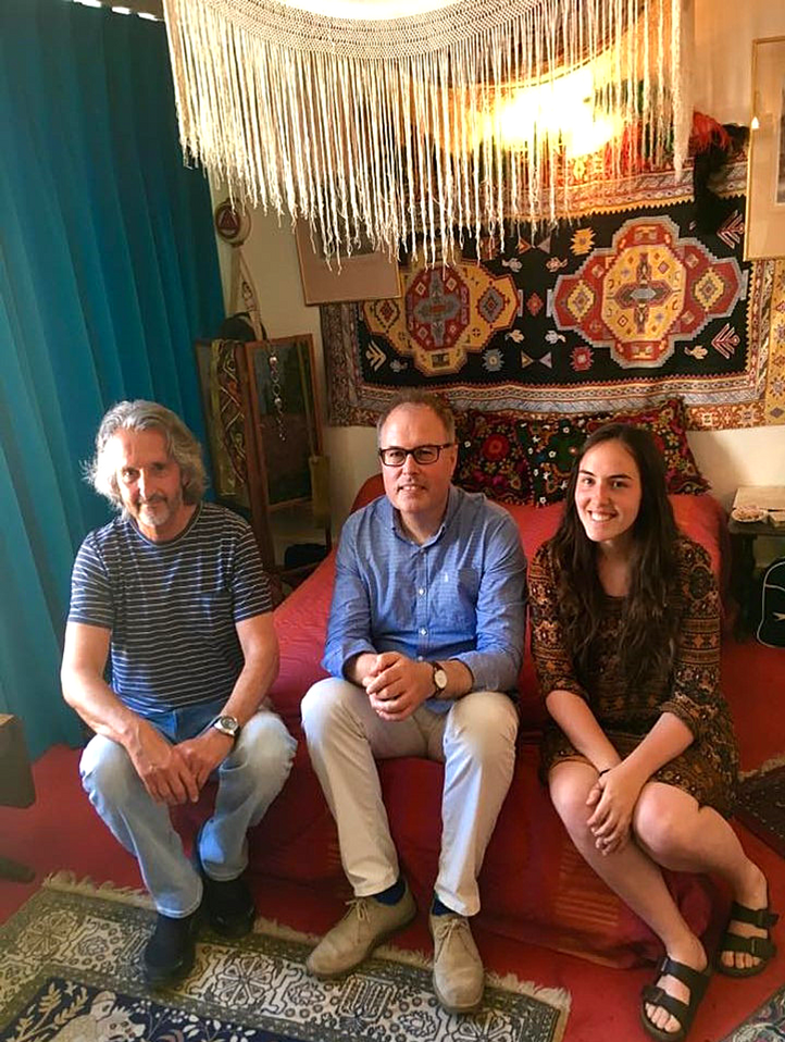 From left to right: Doug Kaye, former neighbour of guitarist legend Jimi Hendrix, Dr. Christopher Lloyd, Academic Director of the Bader International Student Centre, and Jena Hudson (ArtSci’18), USSRF fellow, sit on Jimi Hendrix’s bed in his former apartment while conducting a research interview.