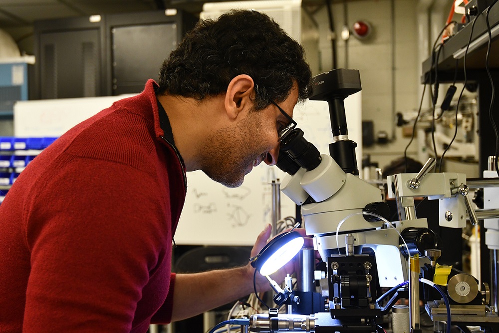 Male researcher looking at a microscope.