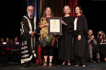 Photograph of Baillie Award recipient Jill Russell with Principal and Vice-Chancellor Patrick Deane, Arts and Science Dean Barbara Crow, and Vice-Provost and Dean of Student Affairs Ann Tierney
