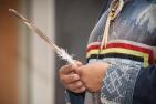 Indigenous person holds a feather
