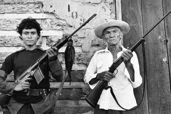 Image of two generations of Latin-American men holding firearms