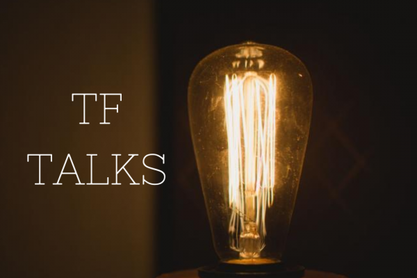 TF Talks poster featuring an Edison lightbulb glowing dimply in a dark room