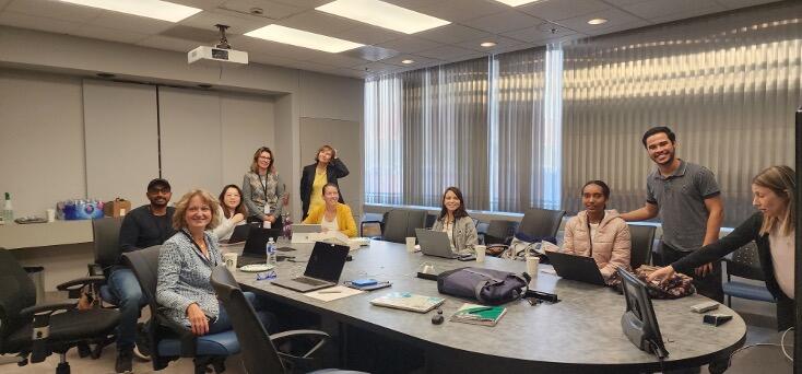 Lab team sitting around the table with computers 