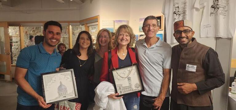 students holding Navjit's art