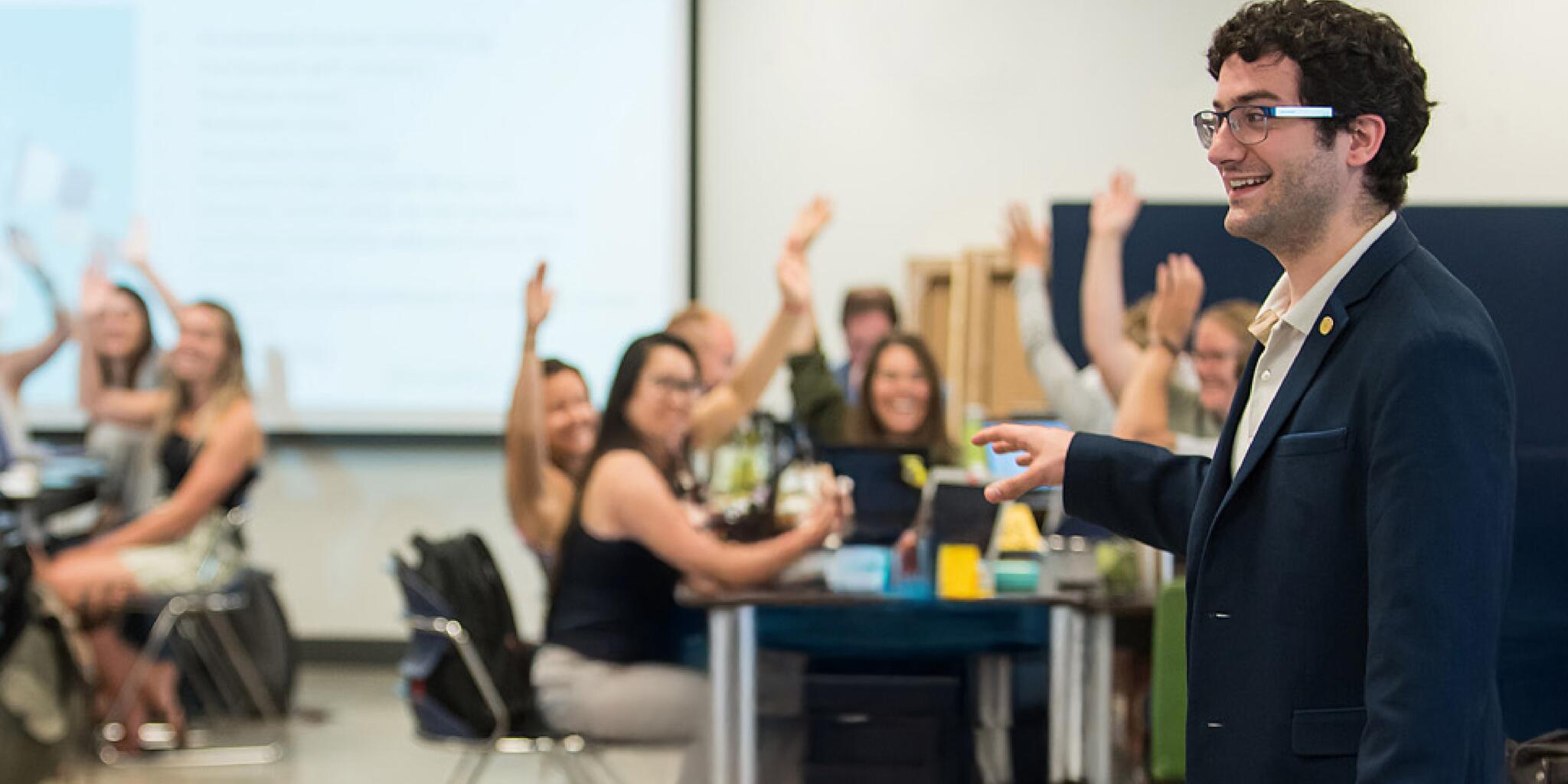 Students in a classroom raising their hands 