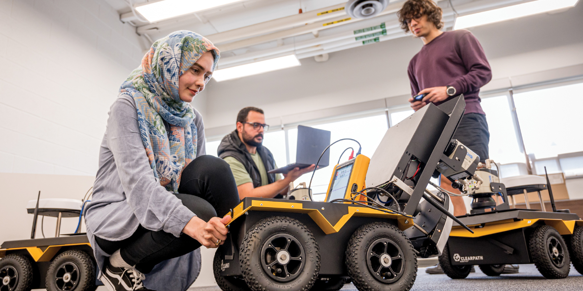 student working with a robotic vehicle