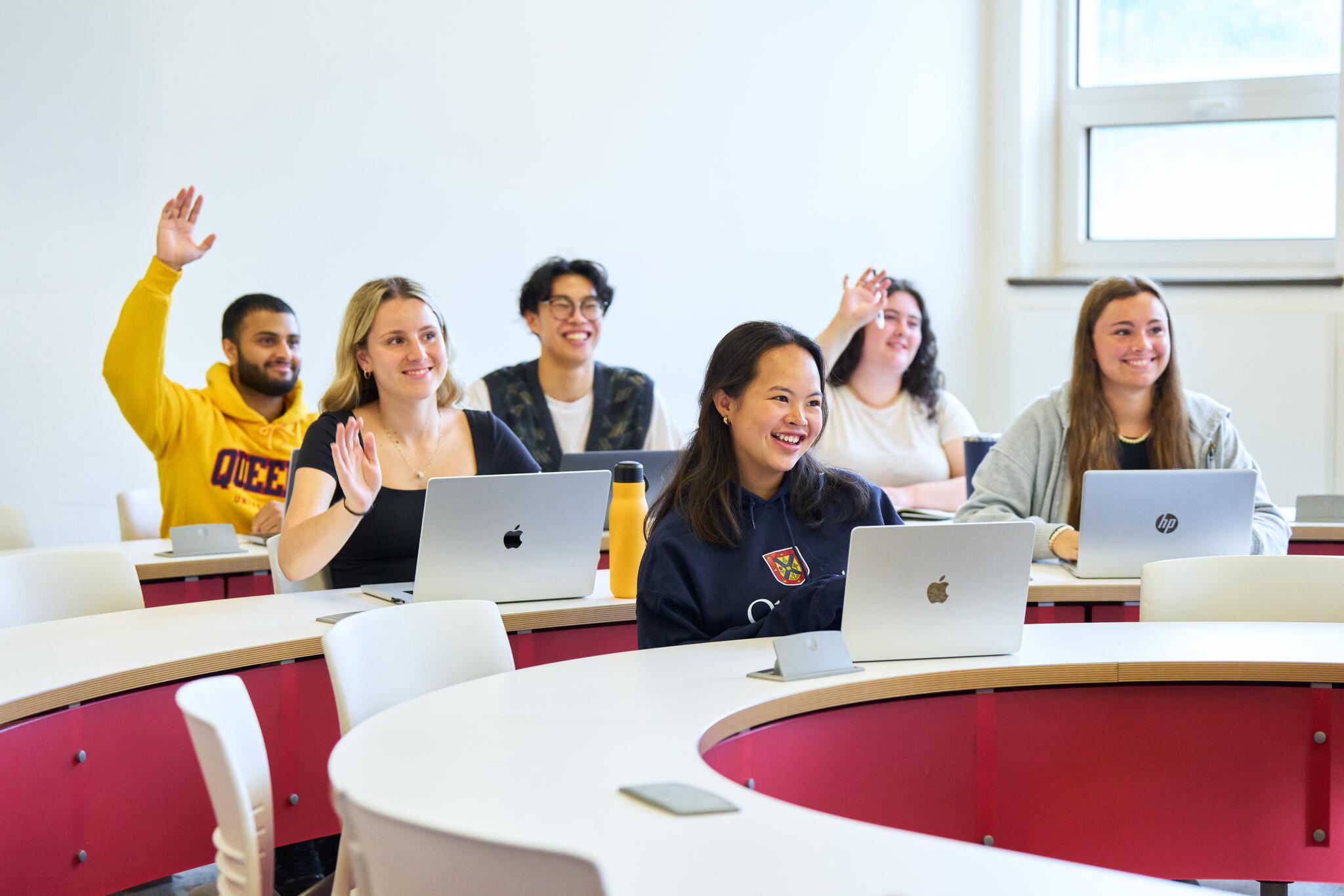 students raising their hands in a class