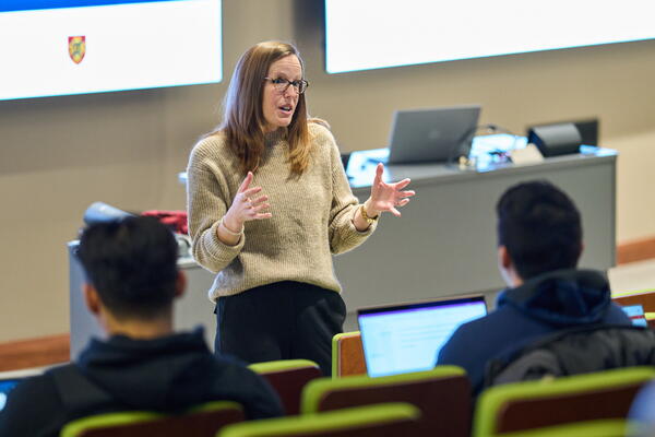 A woman gives a lecture to a room full of students