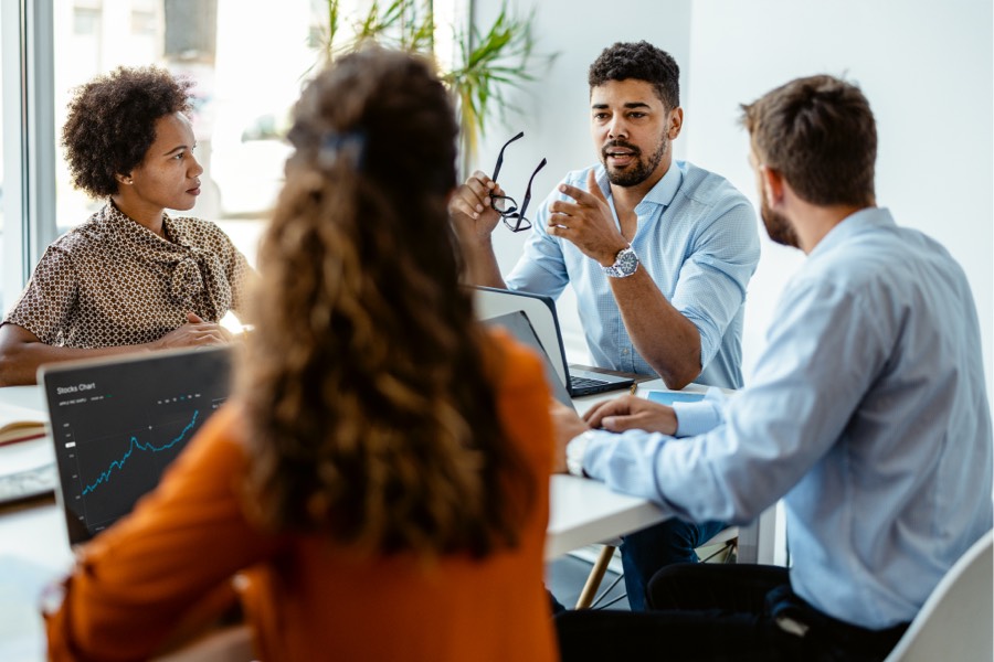 Confident and successful team. Group of people in smart casual wear discussing business while sitting in the creative office