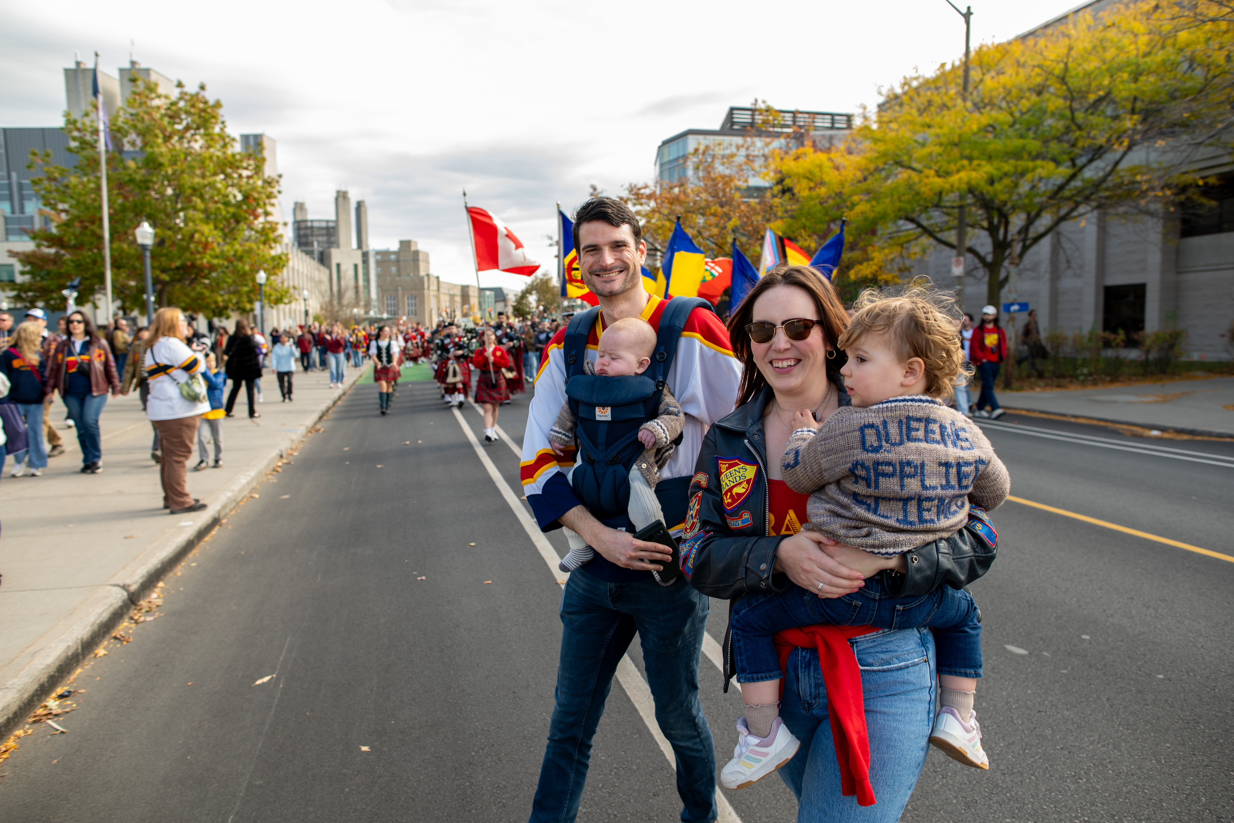A family joins the Alumni Parade to Richardson Stadium during Homecoming 2025, one of many QUAA-supported ways for alumni to reconnect. (Photo: Scott Adamson)