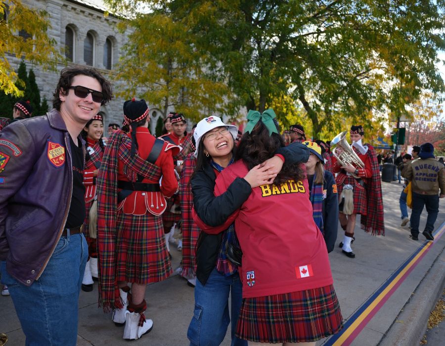 Friends hugging at the Homecoming Parade.
