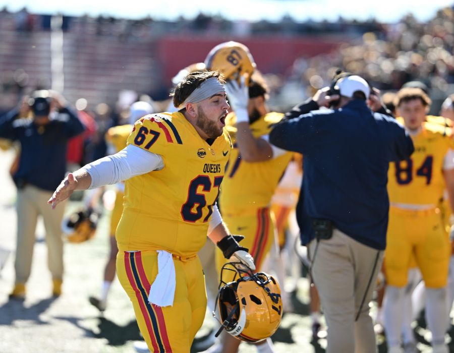 Gaels offensive lineman Riley Sherman celebrating while holding his football helmet.