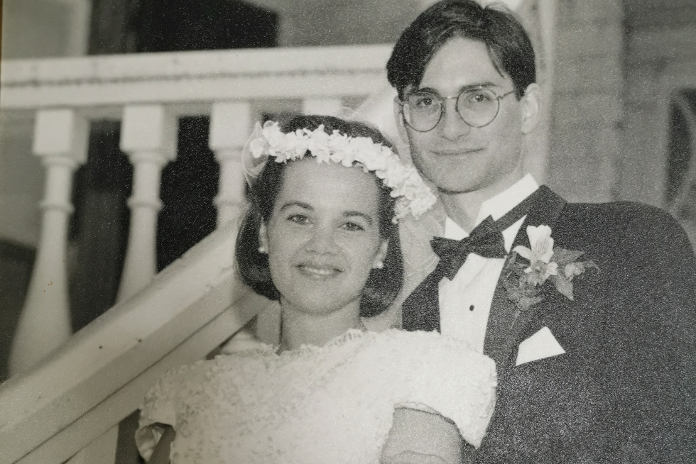Tonya Dickenson, Artsci'89, EMBA'05, and Maxime Tessier, Artsci'88 pose for their wedding photos on the steps of Summerhill on Queen's campus 1992.