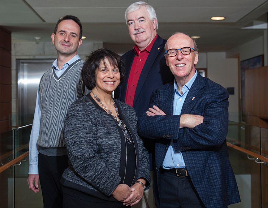 Group of four individuals in an office setting, including Smith Chairs Levin, Salterio, Dacin, and Stephen Smith.
