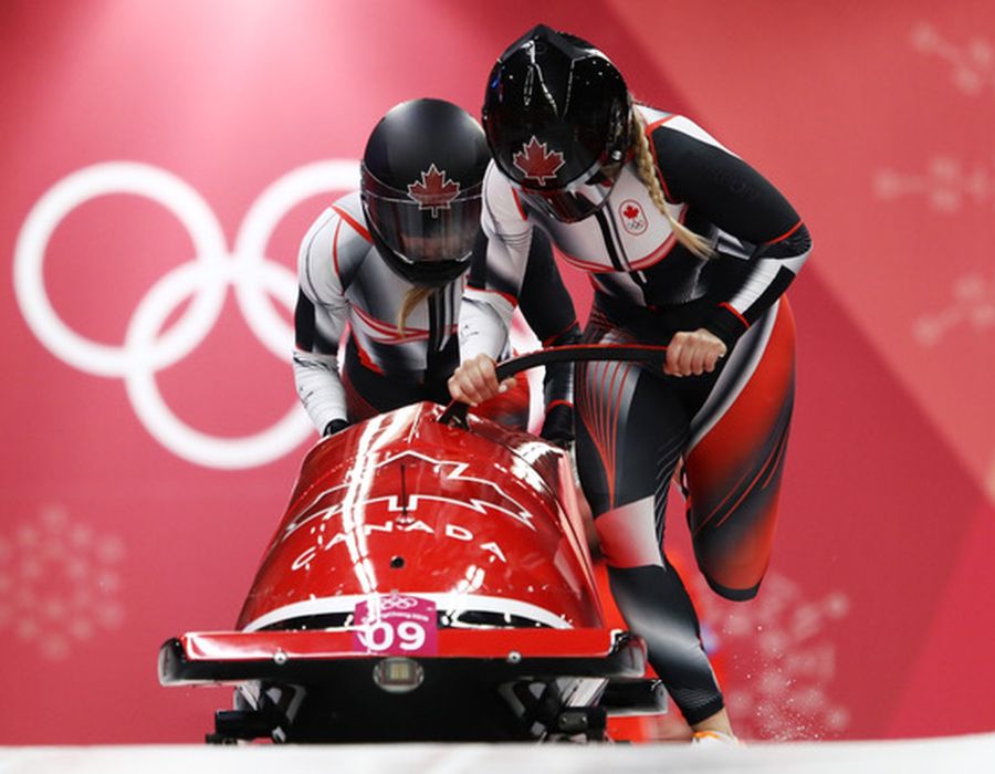 Alysia Olsen and Heather Moyse race in bobsleds down the track, showcasing their competitive spirit and athleticism.