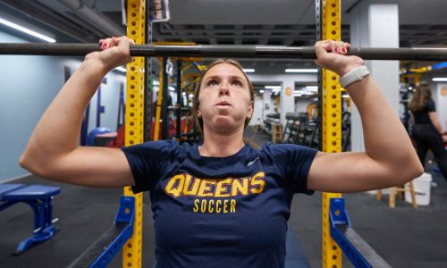 Student lifting weights at the Queen's Gym.