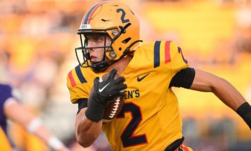 Football player holding the ball during the Homecoming match.