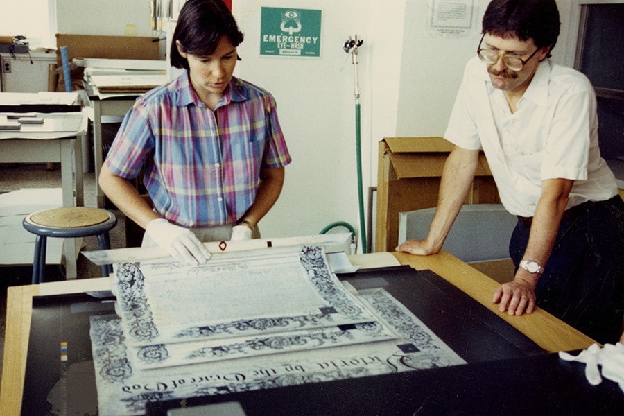 In 1991, conservator Margaret Bignell and archivist Paul Banfield inspect the Royal Charter, a significant historical document.