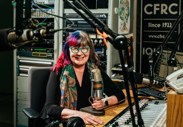 Shelagh Rogers holding a microphone in the CFRC studio