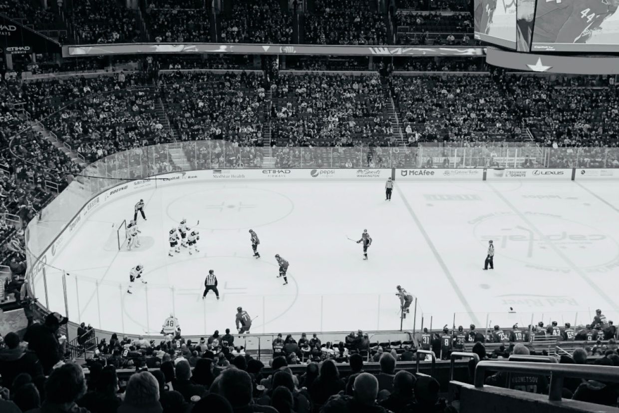 Aerial view from the stands at a hockey area. Hockey players can be seen playing. 