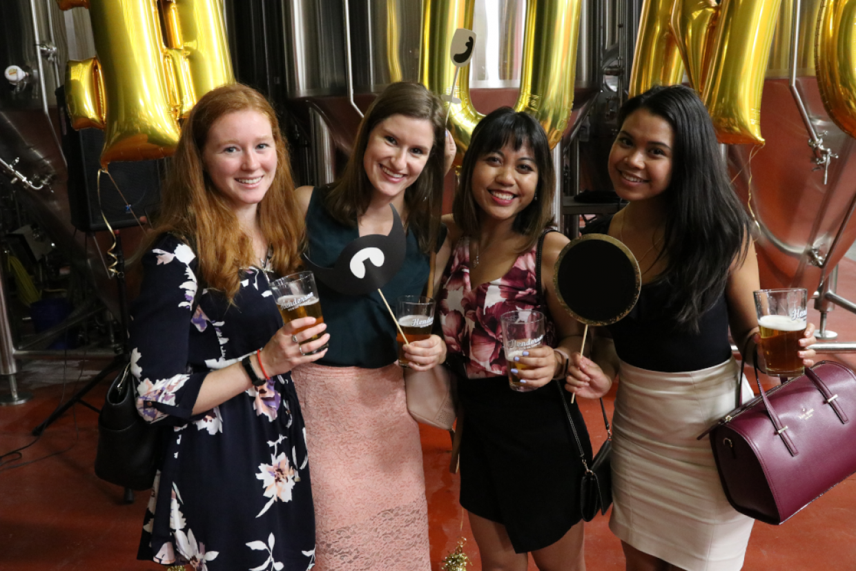 Alumni visiting a brewery pose for a photo.