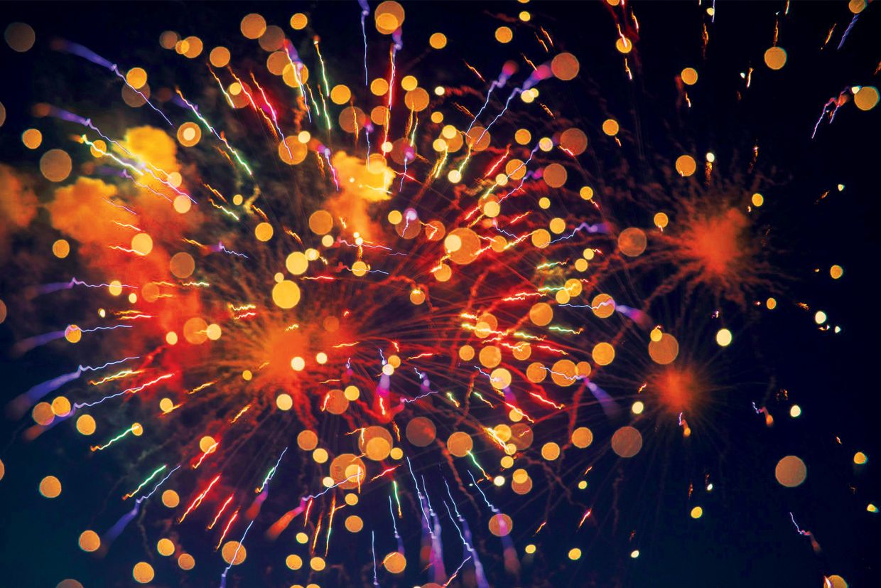 Photo of fireworks in blue, red, and yellow with bokeh