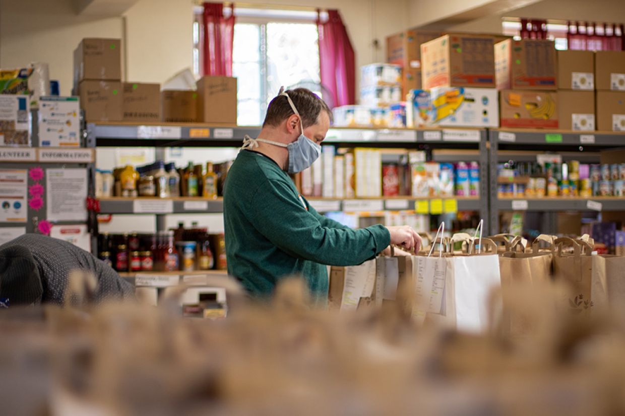 A volunteer packs bags at a food bank