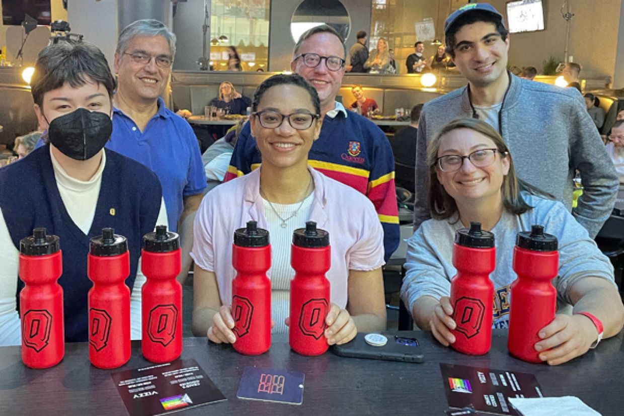Queen's alumni at an event, with Queen's swag.
