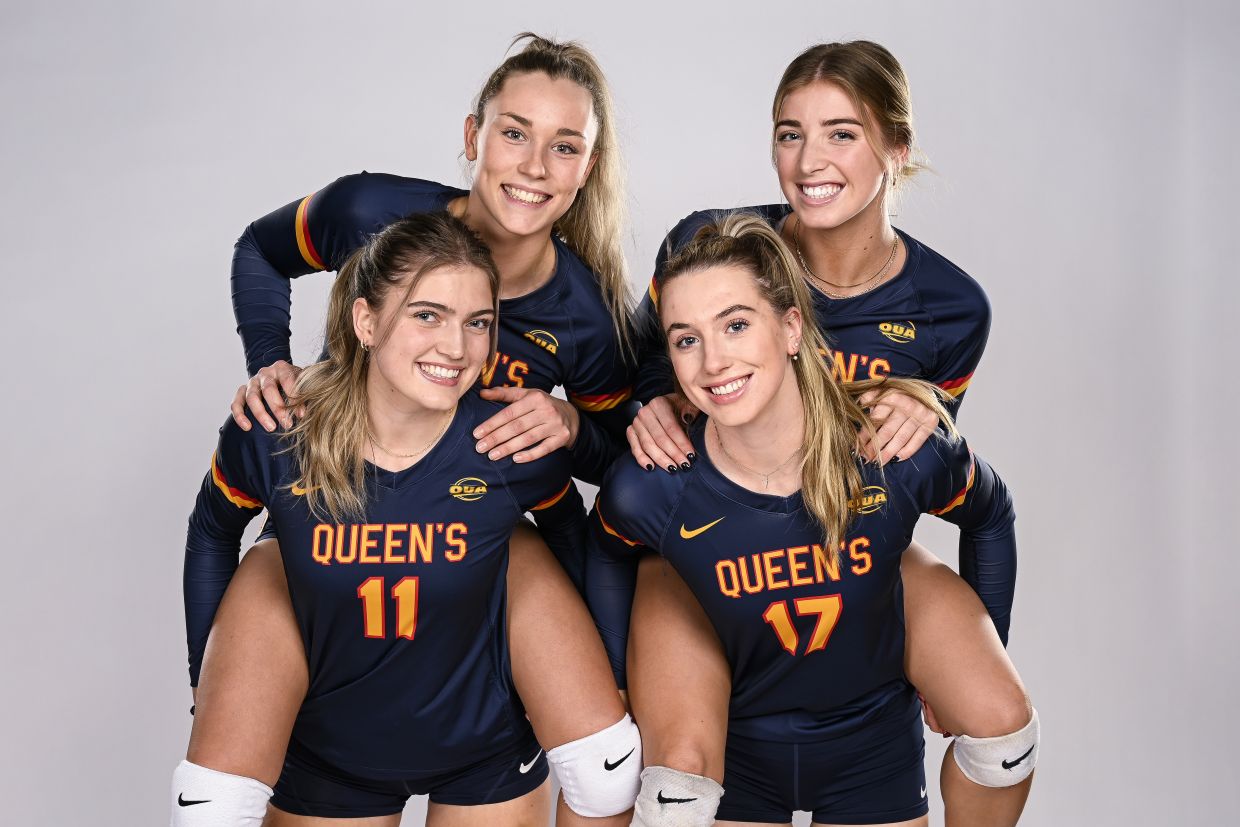 4 Women's Volleyball players posing in uniform