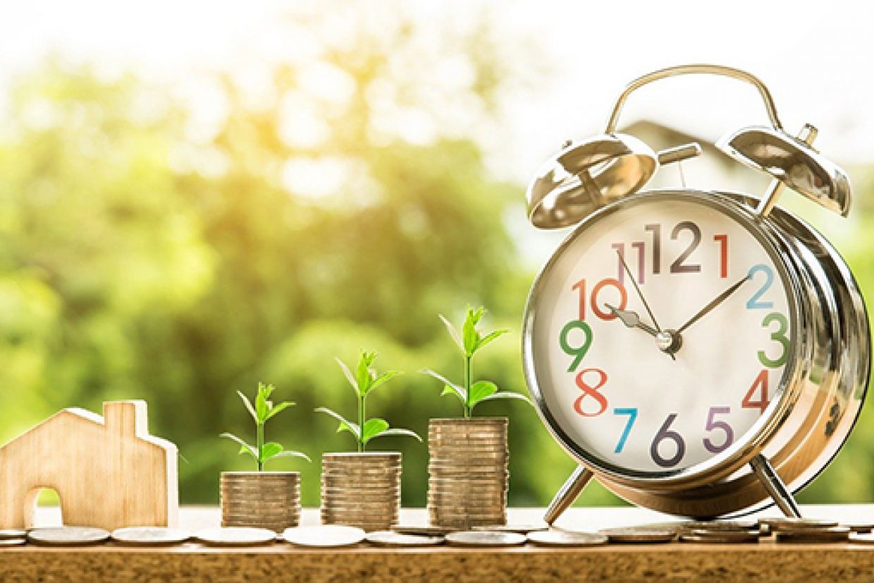 Coins stacked next to a clock.