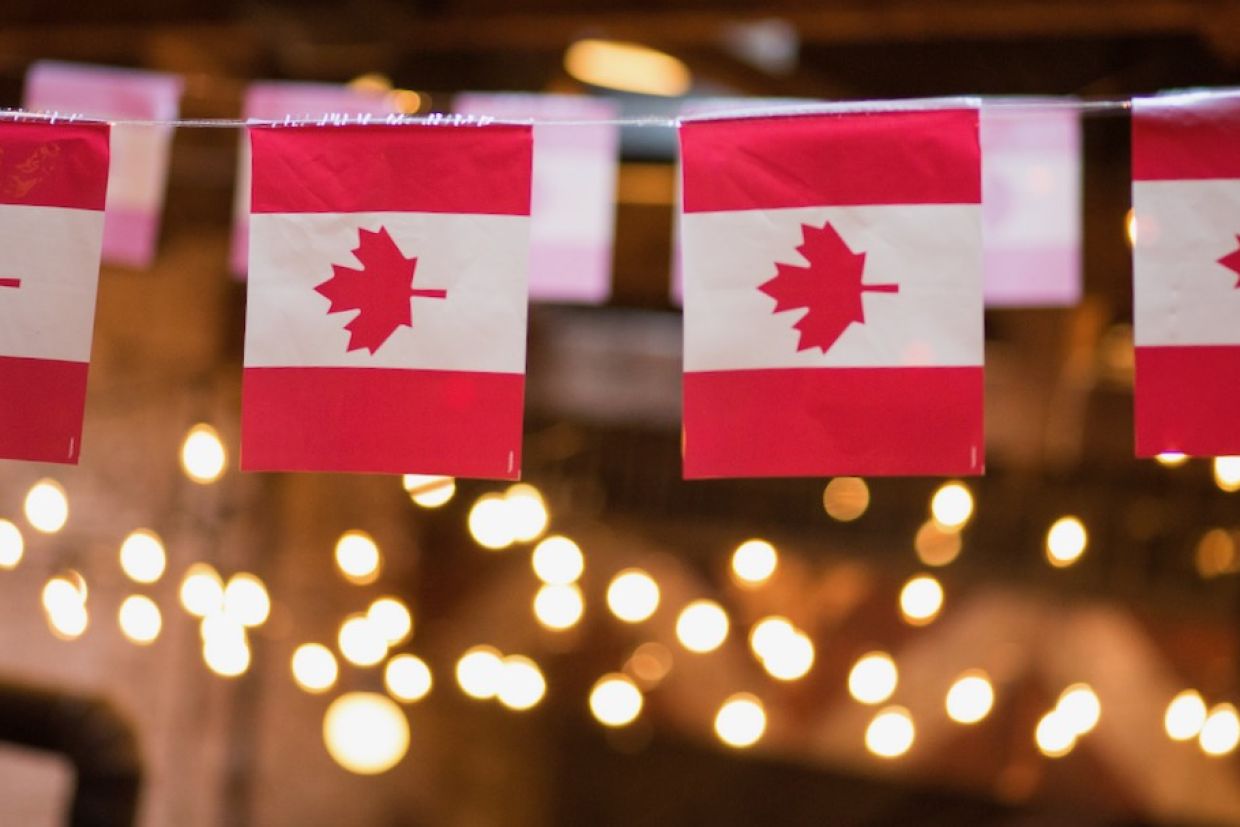 Garland of Canadian flags with string lights in the background.