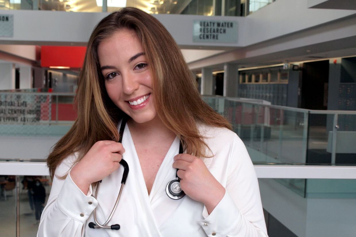 Catherine Davidson wearing a white collar shirt with a stethoscope around their neck
