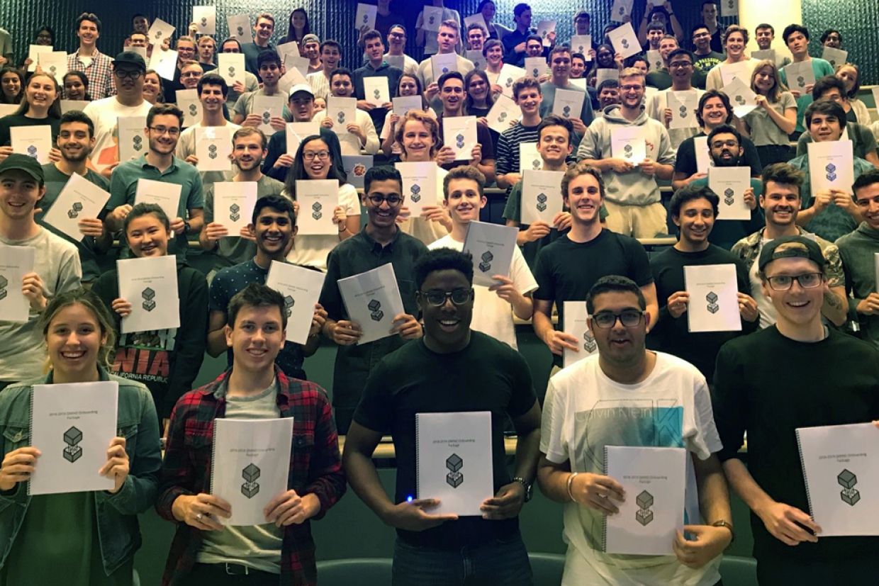 Group of students holding up a piece of paper.