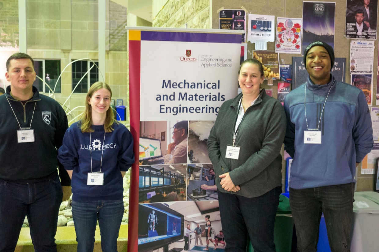 Mechanical and Materials Engineering students stand by a recruitment booth.
