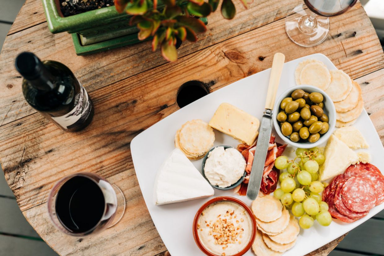 Aerial view of a table displaying an assortment of wine and cheeses.