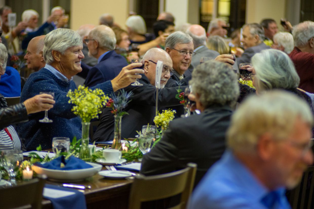 Members of Tricolour Guard raise their glasses while seated for dinner inside Ban Righ Hall.