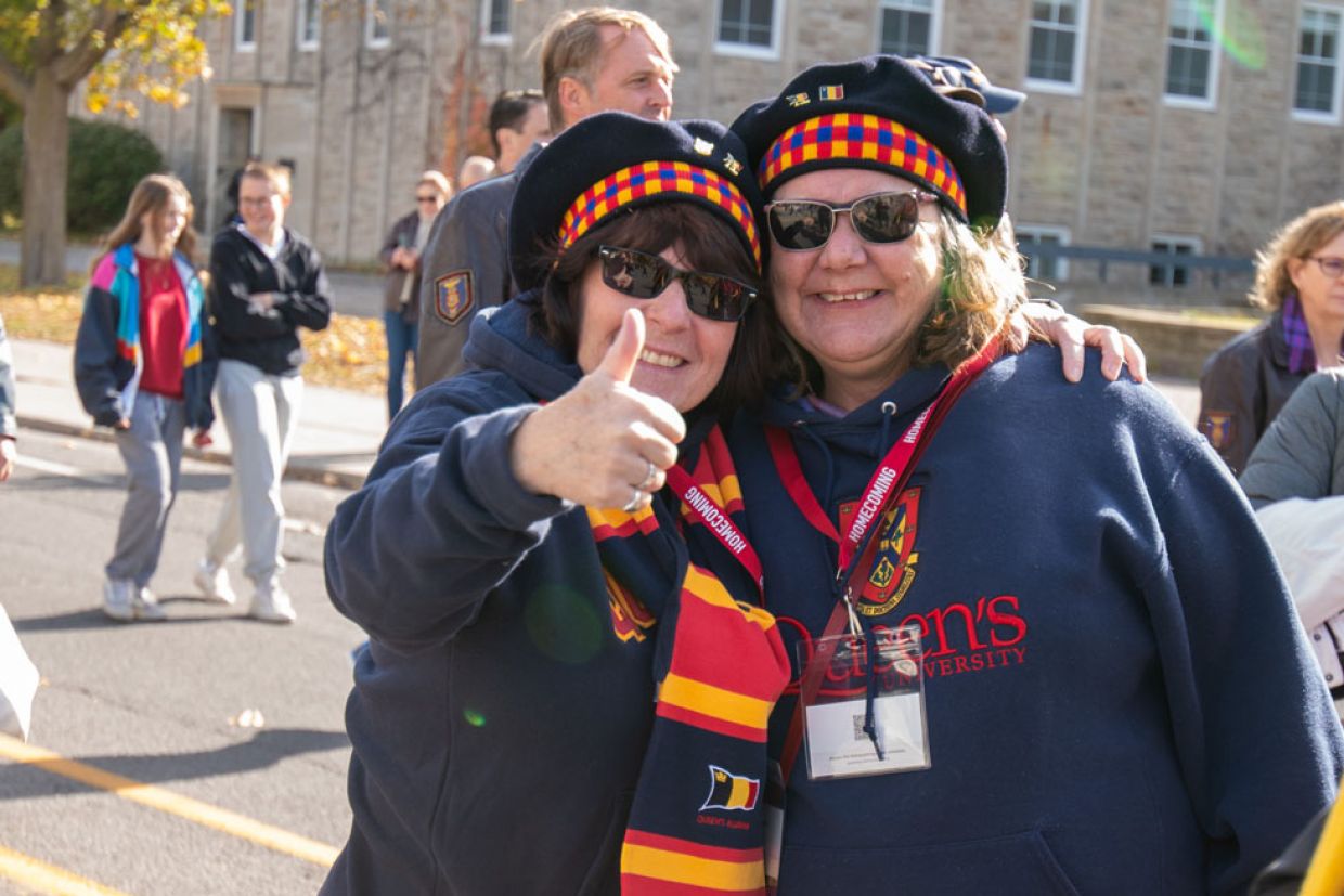 Two alumni posing in tams
