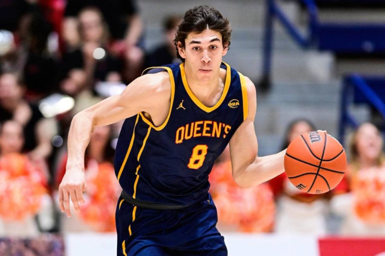 A member of the Gael's men's basketball team wears a blue jersey and dribbles a basketball.