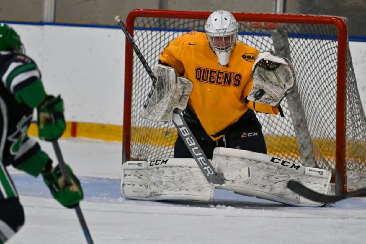 Gael's women's hockey goal prepares to block a shot from an opponent.