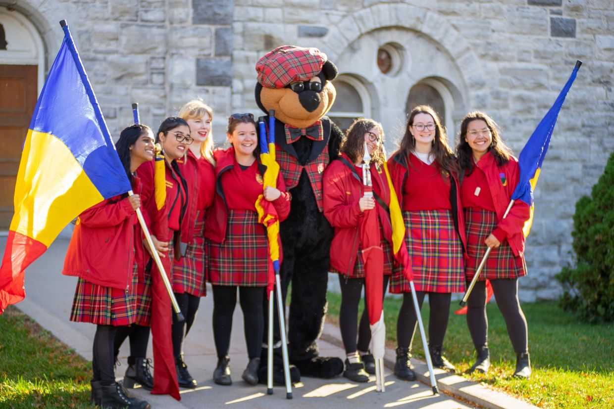 Boo Hoo standing in front of Grant Hall with several Bands members, smiling at the camera.