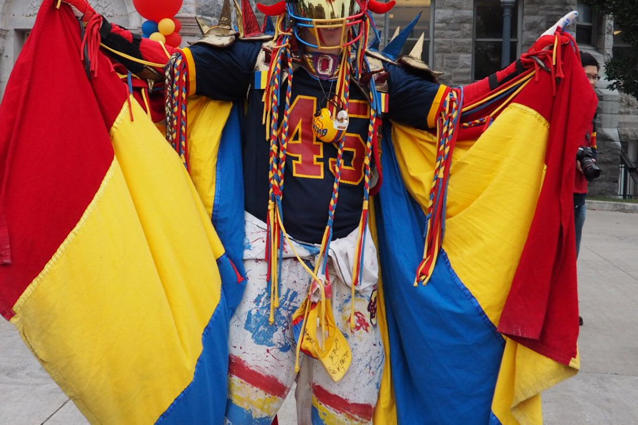 Superfan dressed in Tricolour from head to toe, standing outside of Grant Hall