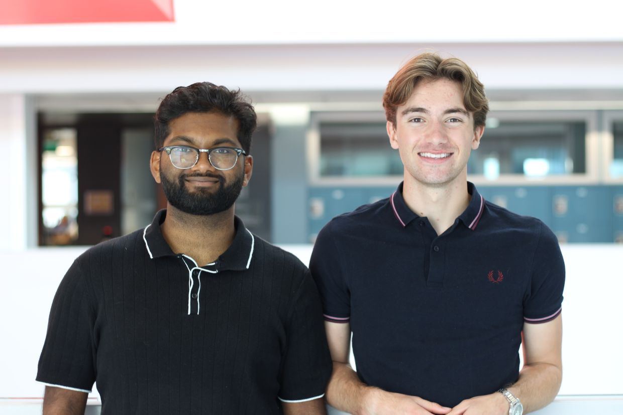 Qlean co-captains Ahnaaf Khan and Jacob Rivelis smiling wearing black polo t-shits. 